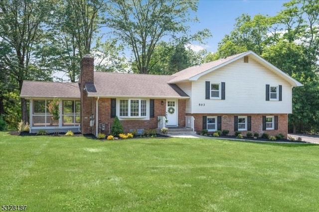 split level home with a sunroom and a front yard