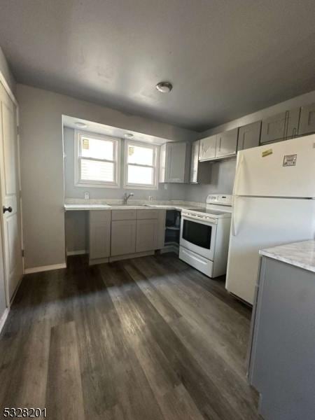 kitchen with gray cabinets, sink, white appliances, and dark wood-type flooring