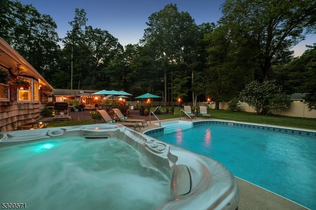 pool at dusk with a jacuzzi