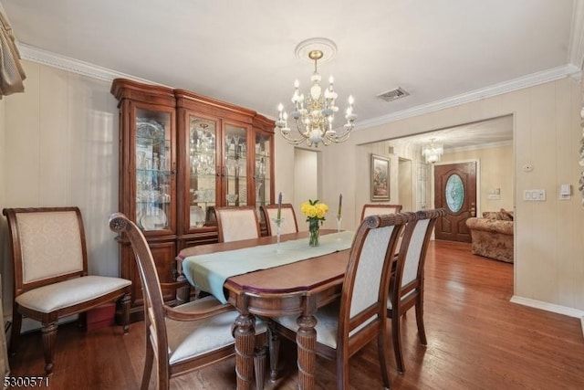 dining area featuring a chandelier, hardwood / wood-style floors, and ornamental molding