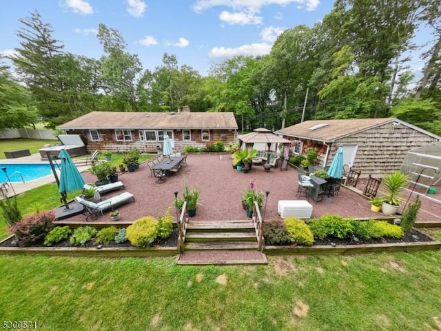 back of property with a gazebo, a patio area, and a lawn