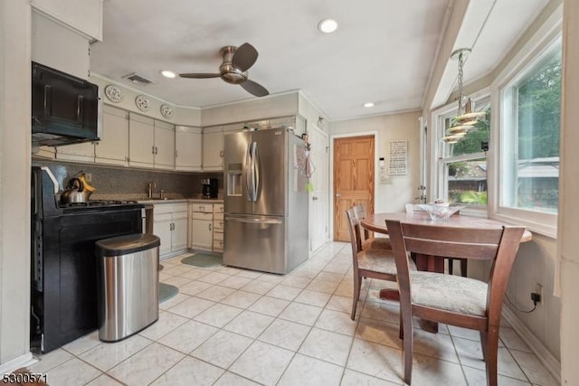 kitchen with sink, ceiling fan, appliances with stainless steel finishes, tasteful backsplash, and decorative light fixtures