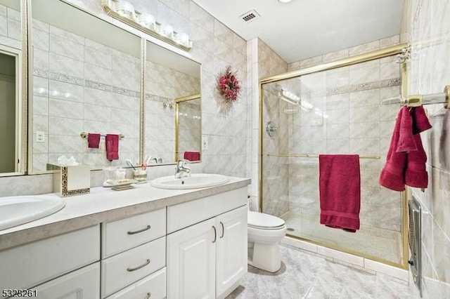 bathroom with vanity, toilet, tile walls, and walk in shower