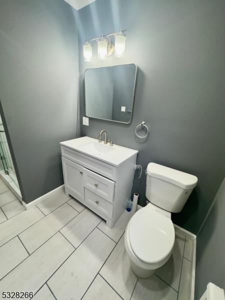 bathroom with tile patterned flooring, vanity, and toilet