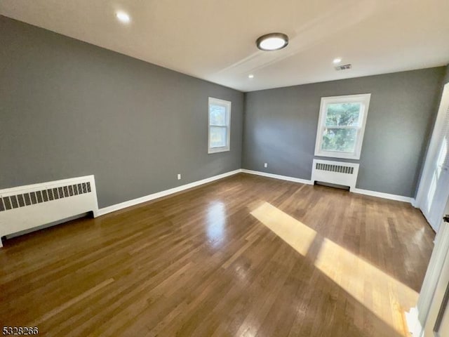 empty room featuring hardwood / wood-style flooring and radiator