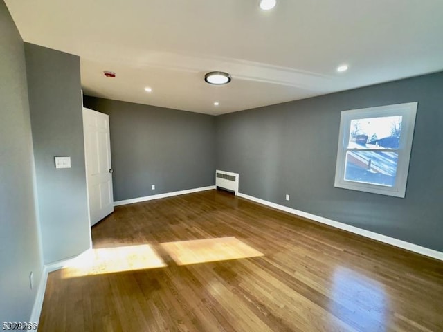 spare room with radiator and wood-type flooring