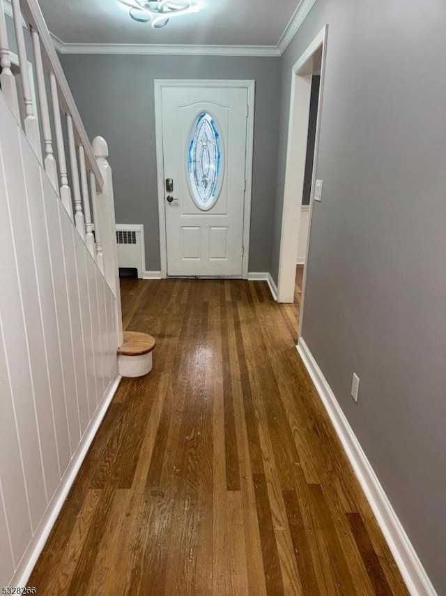 foyer featuring radiator heating unit, dark hardwood / wood-style flooring, and ornamental molding