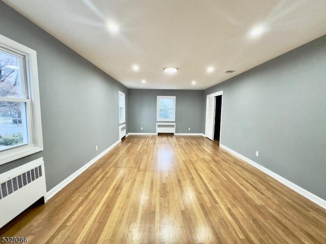 spare room with light wood-type flooring and radiator heating unit