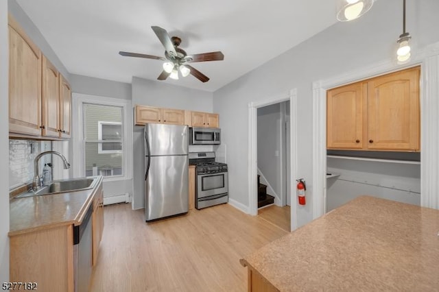 kitchen with light brown cabinetry, sink, light hardwood / wood-style floors, and appliances with stainless steel finishes