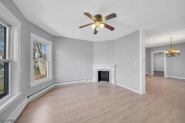 unfurnished living room featuring ceiling fan with notable chandelier, light wood-type flooring, and baseboard heating