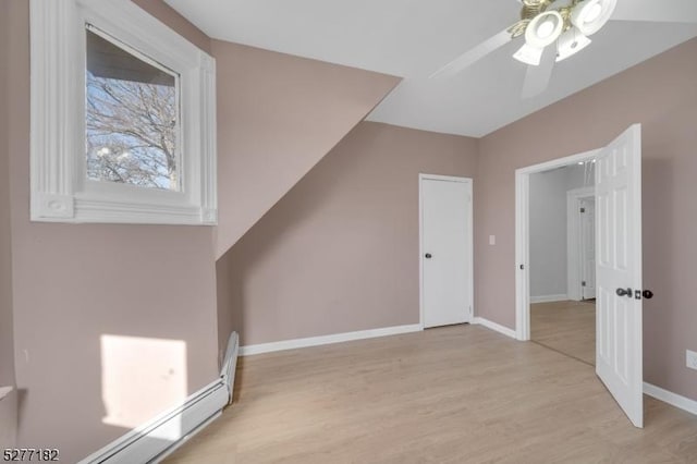 additional living space featuring ceiling fan, a baseboard radiator, and light hardwood / wood-style flooring