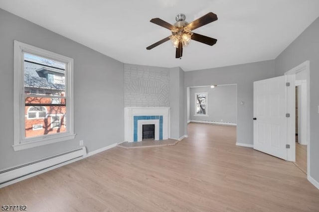 unfurnished living room featuring a fireplace, ceiling fan, light hardwood / wood-style flooring, and a baseboard radiator