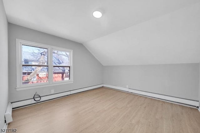 bonus room with light hardwood / wood-style floors, lofted ceiling, and a baseboard heating unit