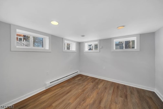 basement featuring baseboard heating and dark hardwood / wood-style floors