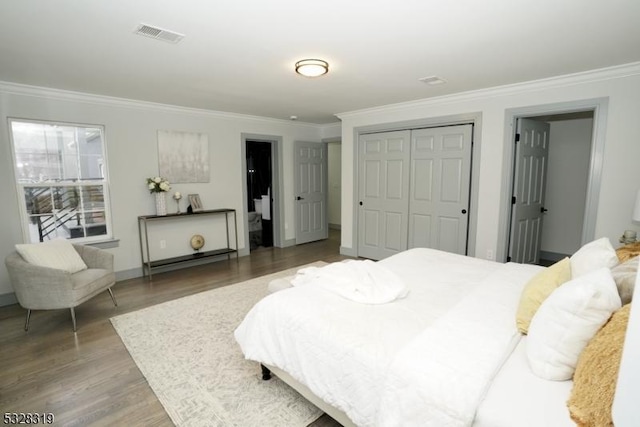 bedroom featuring hardwood / wood-style flooring, ornamental molding, and a closet