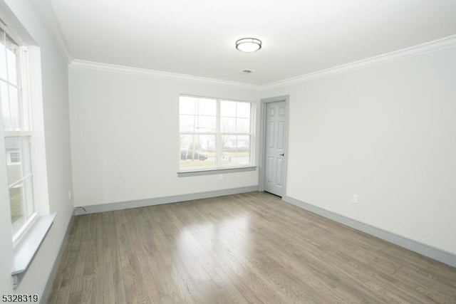 empty room featuring ornamental molding and light hardwood / wood-style flooring