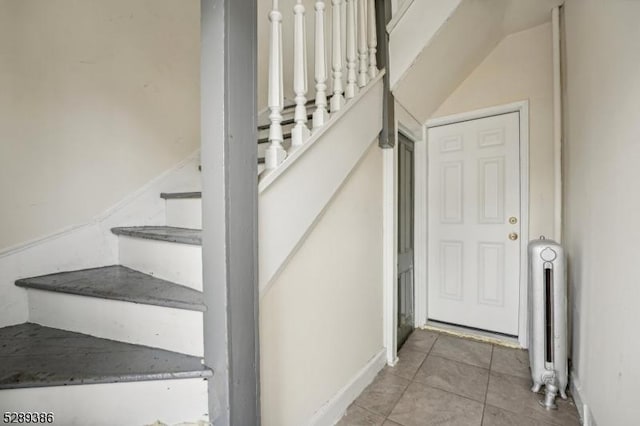 stairway with tile patterned floors and radiator