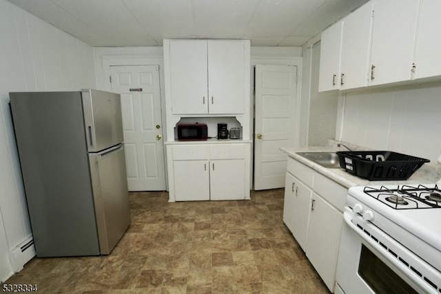 kitchen featuring white cabinets, white stove, stainless steel refrigerator, and sink