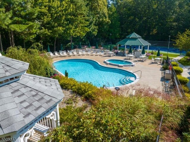 community pool featuring fence, a gazebo, a patio, and a community hot tub