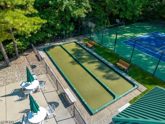 view of home's community with a tennis court and fence