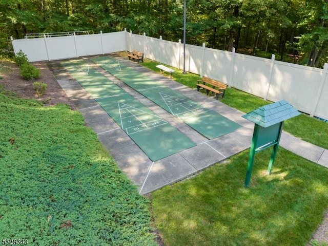 surrounding community featuring a yard, fence, and shuffleboard