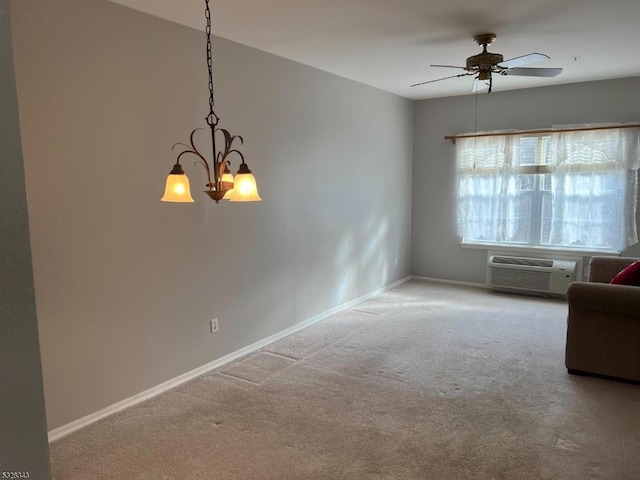 unfurnished room featuring baseboards, ceiling fan with notable chandelier, a wall unit AC, and carpet floors