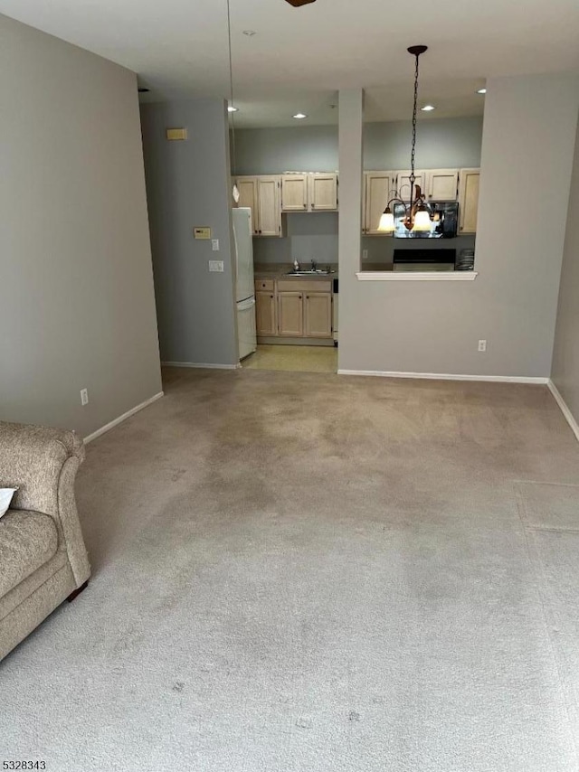 unfurnished living room with light carpet, recessed lighting, baseboards, and a sink