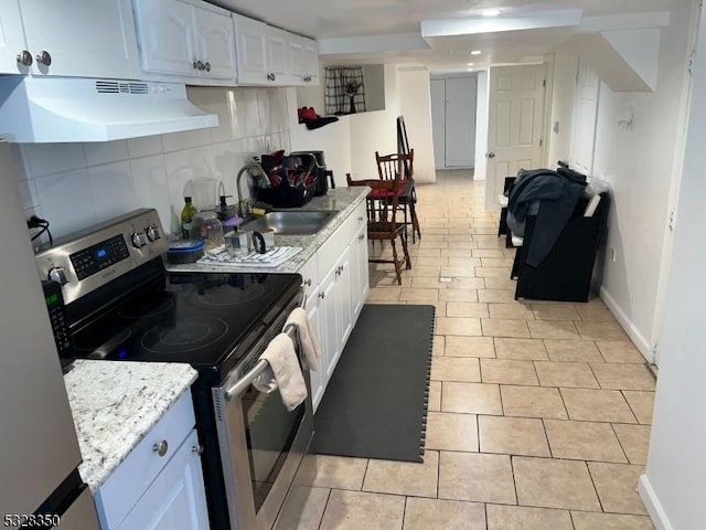 kitchen with sink, tasteful backsplash, range hood, stainless steel electric range, and white cabinets