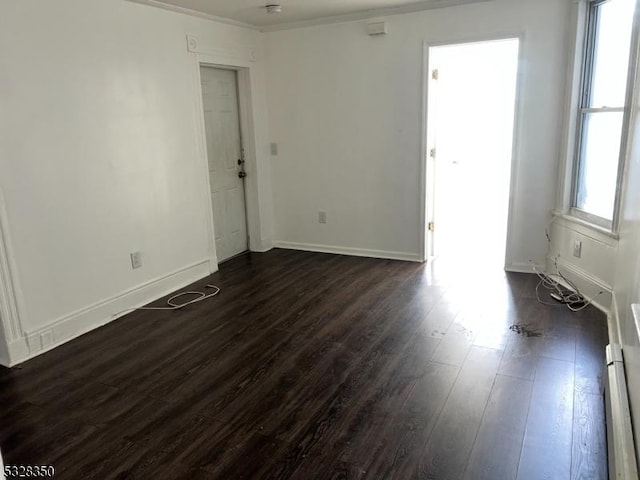 unfurnished room featuring dark hardwood / wood-style floors and crown molding