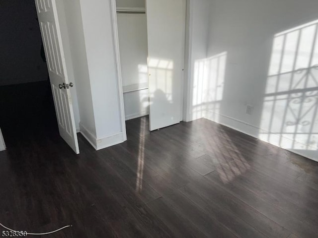 unfurnished bedroom featuring dark hardwood / wood-style floors and a closet