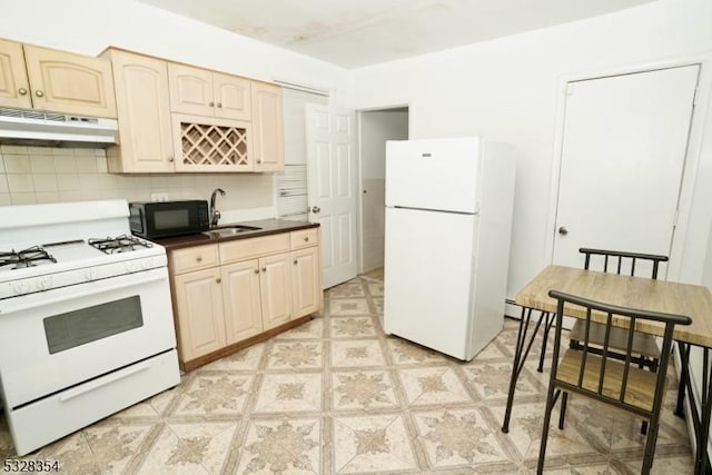 kitchen with tasteful backsplash, light brown cabinetry, sink, and white appliances