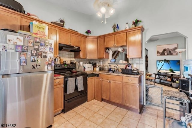 kitchen featuring sink, black electric range, decorative backsplash, stainless steel fridge, and light tile patterned flooring