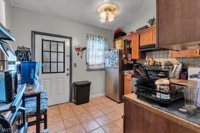 kitchen featuring backsplash, stainless steel appliances, and light tile patterned flooring