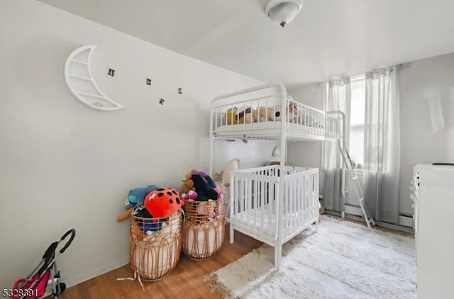 bedroom with a crib and hardwood / wood-style flooring