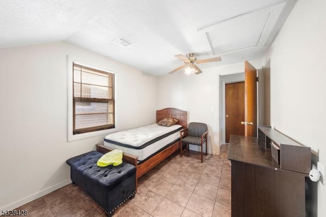 bedroom featuring ceiling fan, lofted ceiling, a textured ceiling, and light tile patterned floors