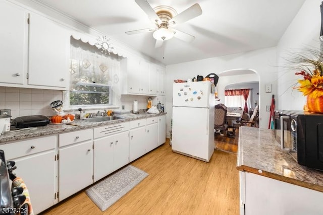 kitchen featuring white cabinets, ceiling fan, white fridge, and light hardwood / wood-style flooring