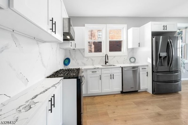 kitchen featuring white cabinets, stainless steel appliances, and plenty of natural light