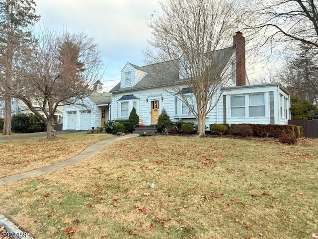 new england style home with a front yard and a garage