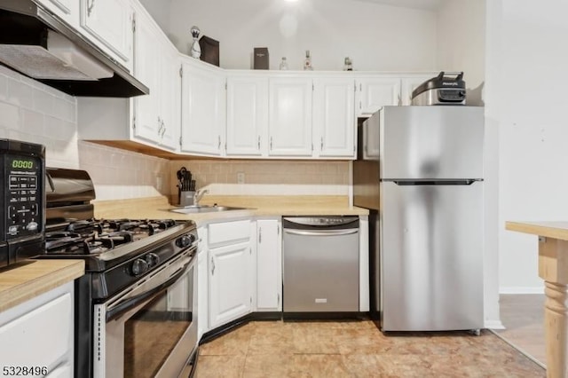 kitchen featuring appliances with stainless steel finishes, tasteful backsplash, sink, light tile patterned floors, and white cabinets