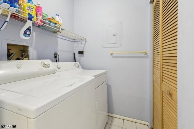 laundry area with washer and dryer, electric panel, and light tile patterned flooring