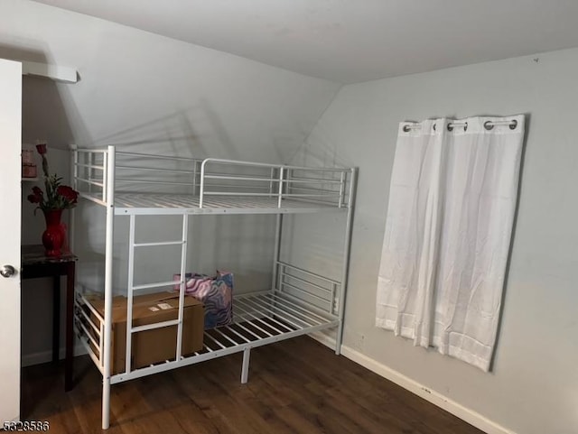 bedroom featuring dark wood-type flooring and lofted ceiling