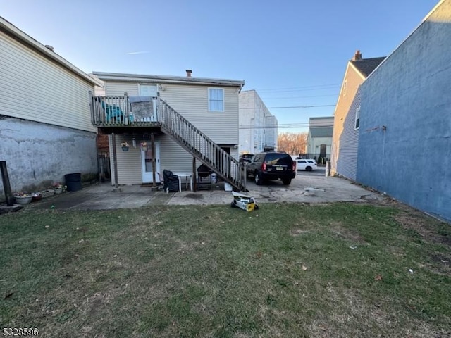 rear view of house featuring a yard and a wooden deck