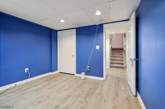 spare room with light hardwood / wood-style floors and a drop ceiling