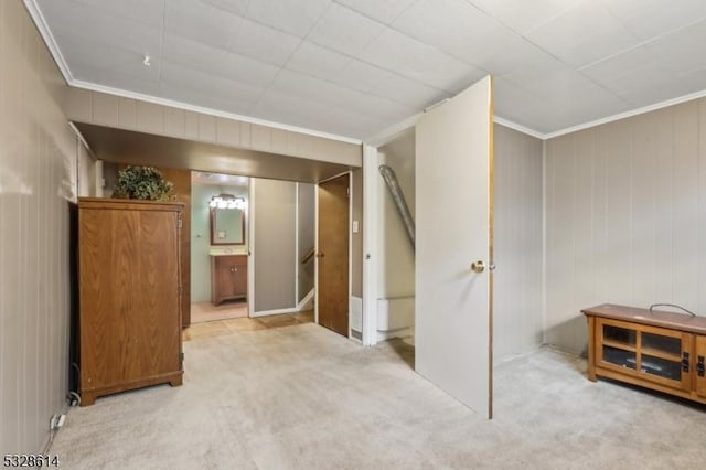 unfurnished bedroom with connected bathroom, crown molding, and light colored carpet