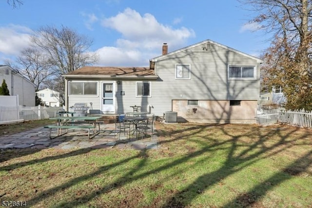 rear view of property with a patio area, a yard, and cooling unit