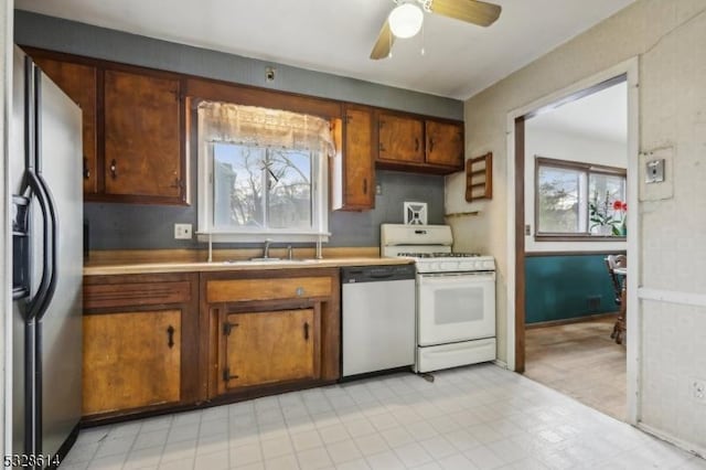 kitchen featuring white appliances, ceiling fan, and sink