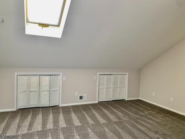 interior space with dark colored carpet and lofted ceiling