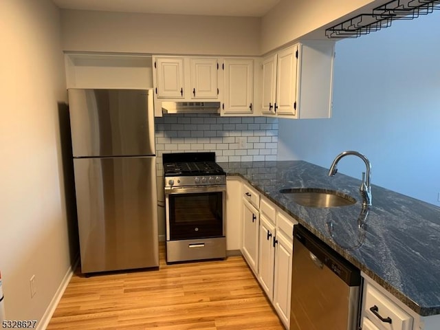 kitchen with sink, appliances with stainless steel finishes, tasteful backsplash, light hardwood / wood-style floors, and white cabinetry