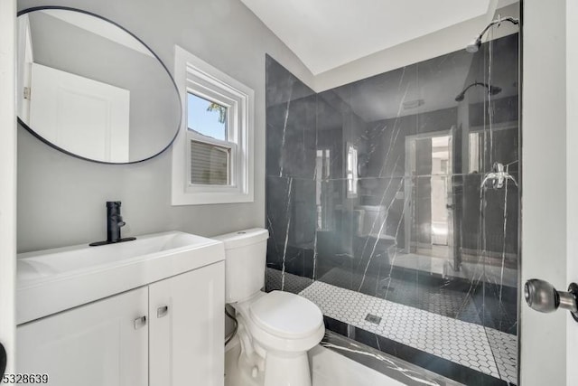 bathroom with vanity, toilet, and tiled shower