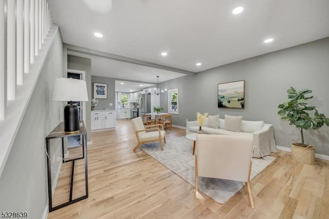 living room featuring a chandelier and light wood-type flooring